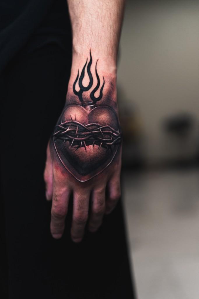Heart and barbed wire hand tattoo
