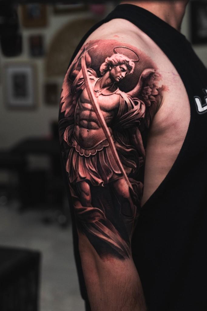 Angel statue arm tattoo